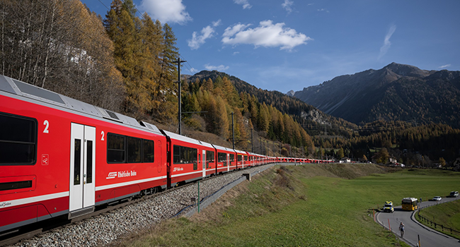 A 1910-metre-long train with 100 cars passes near Bergun, on October 29, 2022, during a record attempt by the Rhaetian Railway (RhB) of the World's longest passenger train, to mark the Swiss railway operator's 175th anniversary. (Photo by Fabrice COFFRINI / AFP)