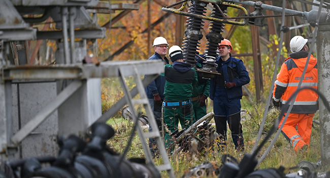 Workers repair equipments of power lines destroyed after a missile strike on a power plant, in an undisclosed location of Ukraine, on October 27, 2022, amid the Russian invasion of Ukraine. (Photo by Sergei SUPINSKY / AFP)