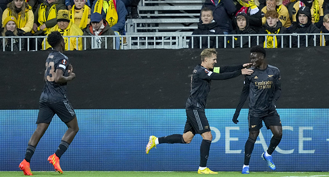 Arsenal's English midfielder Bukayo Saka (R) celebrates with Arsenal's Norwegian midfielder Martin Odegaard and Arsenal's Belgian midfielder Albert Sambi Lokonga after scoring a goal during the UEFA Europa League Group A football match between FK Bodoe/Glimt and Arsenal FC in Bodo, Norway on October 13, 2022. (Photo by Fredrik Varfjell / NTB / AFP)