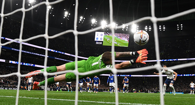 Tottenham Hotspur's English striker Harry Kane (reat) shoots a penalty kick past Everton's English goalkeeper Jordan Pickford (front) and scores his team first goal during the English Premier League football match between Tottenham Hotspur and Everton at Tottenham Hotspur Stadium in London, on October 15, 2022. (Photo by Daniel LEAL / AFP)