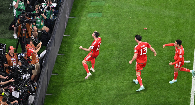 Wales' forward #11 Gareth Bale (L) celebrates after scoring his team's first goal from the penalty spot during the Qatar 2022 World Cup Group B football match between USA and Wales at the Ahmad Bin Ali Stadium in Al-Rayyan, west of Doha on November 21, 2022. (Photo by Antonin THUILLIER / AFP)