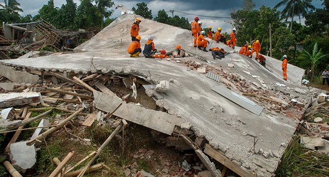 Rescue workers look for victims under the ruins of collapsed buildings in Cianjur on November 22, 2022, following a 5.6-magnitude earthquake that killed at least 162 people, with hundreds injured and others missing. (Photo by TIMUR MATAHARI / AFP)