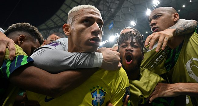 Brazil's forward #09 Richarlison (2nd L) celebrates with teammates after scoring his team's first goal during the Qatar 2022 World Cup Group G football match between Brazil and Serbia at the Lusail Stadium in Lusail, north of Doha on November 24, 2022. (Photo by NELSON ALMEIDA / AFP)