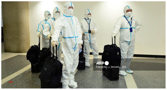 In this file photo taken on December 3, 2021, the flight crew from Air China arrive in hazmat suits in the international terminal at Los Angeles International Airport. (Photo by Frederic J. BROWN / AFP) / NO USE AFTER JANUARY 27, 2023.