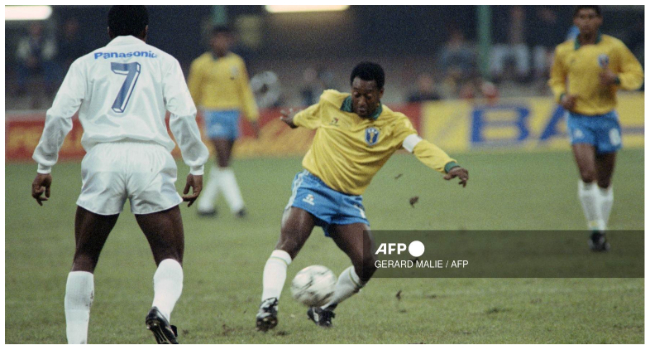 In this file photo taken on October 31, 1990 Former Brazilian soccer star, Edson Arantes do Nascimento, known as Pelé (L), plays the ball during a friendly soccer match opposing Brazil to world soccer star to celebrate Pele's fiftieth birtday in Milan. Brazilian football icon Pele, widely regarded as the greatest player of all time and a three-time World Cup winner who masterminded the 'beautiful game', died on December 29, 2022 at the age of 82, after battling kidney problems and colon cancer. (Photo by Gerard MALIE / AFP) / NO USE AFTER JANUARY 2, 2023 14:59:27 GMT
