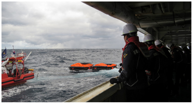 This handout photo taken on January 25, 2023 and provided by the Korea Coast Guard shows coast guard members searching for missing people after a Hong Kong cargo ship sank off South Korea's southern island of Jeju. (Photo by Handout / KOREA COAST GUARD / AFP)