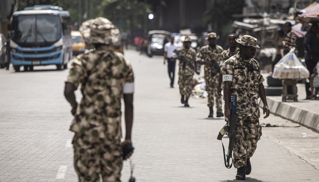 PHOTOS: Armed Military Personnel Keep The Peace In Lagos Island Market
