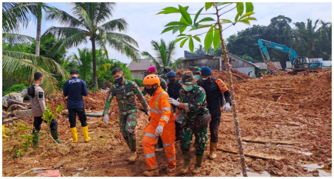 This handout picture taken on March 8, 2023 and released on March 9, 2023 by ministry of communication and information shows rescue team evacuate the body of a victim that was found buried by a landslide at Pangkalan village, in Natuna Islands. (Photo by Handout / Natuna ministry of communication / AFP)