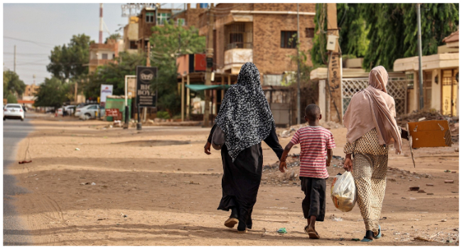 Women and a boy walk along a street in Khartoum on April 18, 2023. Explosions rocked the Sudanese capital Khartoum on April 18, the fourth day of fighting that has claimed nearly 200 lives despite growing international calls for an end to hostilities that have spawned increasing lawlessness. (Photo by AFP)