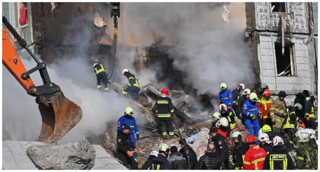 Rescuers search for survivors in the rubble next to a damaged residential building in Uman, southern Kyiv on April 28, 2023, after Russian missile strikes targeted several Ukrainian cities overnight. (Photo by Sergei SUPINSKY / AFP)