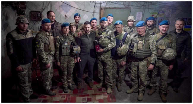 This handout photograph taken and released by Ukrainian Presidential press-service on May 23, 2023 shows the Ukrainian President Volodymyr Zelensky (CL) posing for the picture with servicemen he decorated during his visit to the forward positions of the Armed Forces of Ukraine in the Vugledar-Maryinka defense zone, Donetsk region, on the occasion of the Marine Day, amid the Russian invasion of Ukraine. (Photo by Handout / AFP)