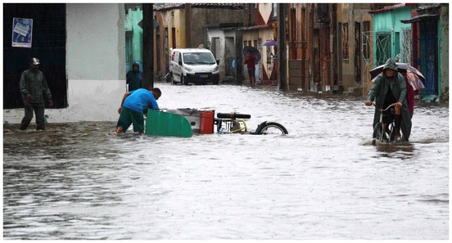 In this handout picture released by ACN people are seen on a street after heavy rains caused a flood in Camaguey, Cuba on June 9, 2023. (Photo by Rodolfo BLANCO CUE / ACN / AFP)