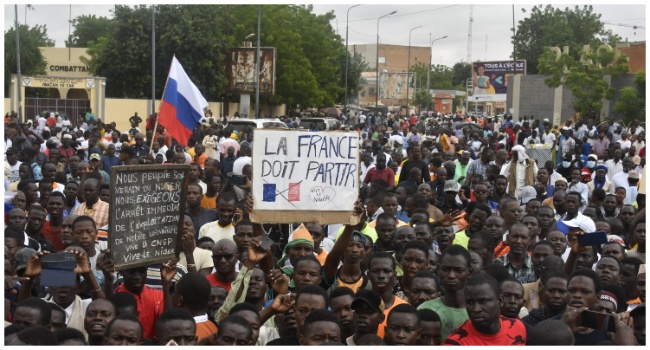 Protesters hold an anti-France placard during a demonstration on independence day in Niamey on August 3, 2023. (Photo by AFP)
