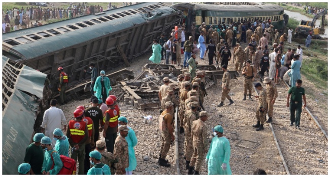 Paramilitary rangers and volunteers inspect the carriages at the accident site following the derailment of a passenger train in Nawabshah on August 6, 2023.(Photo by Husnain ALI / AFP)