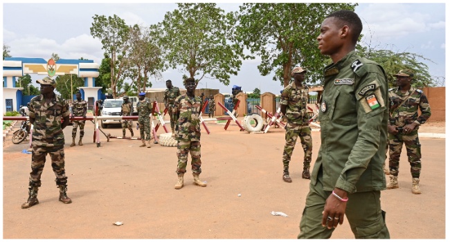 Nigerien soldiers stand guard as supporters of Niger's National Council for the Safeguard of the Homeland (CNSP) gather for a demonstration in Niamey on August 11, 2023 near a French airbase in Niger. (Photo by AFP)