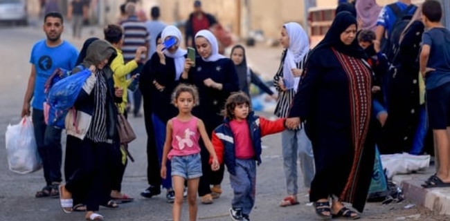 Image of People carrying their belongings flee to safer areas in Gaza City