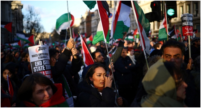 Pro-Palestinian activists and supporters wave flags and carry placards during a National March for Palestine in central London on December 9, 2023, calling for full ceasefire in the war in Gaza.
