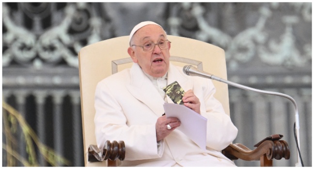 Pope Francis holds a small new Testament from a 23 year old soldier which died in Ukraine during his weekly general audience in St.Peter's square at the Vatican on April 3, 2024. (Photo by Alberto PIZZOLI/AFP)