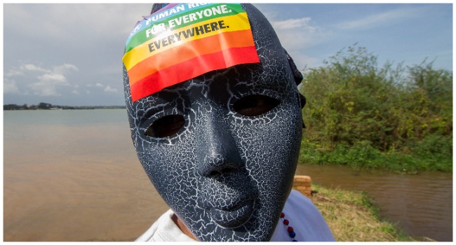 A Ugandan wearing a mask with a rainbow sticker takes part in the Gay Pride parade in Entebbe on August 8, 2015. (Photo by AFP)