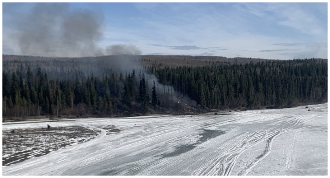 This handout photo released by Alaska State Troopers on April 23, 2024 shows smoke rising from the site of a plane crash outside Fairbanks, Alaska, after a Douglas DC-4 crashed into the Tanana River after taking off from Fairbanks International Airport. (Photo by Alaska State Troopers / AFP)