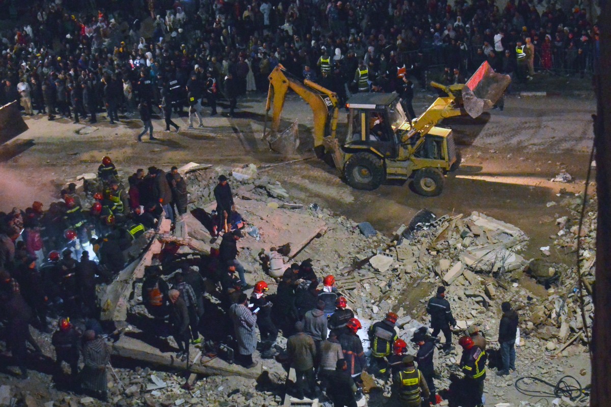 Emergency personnel search for victims in the rubble of two collapsed buildings in the Al Massira area of Fes late on December 9, 2025. Photo by AHMED ALAOUI MRANI / AFP
